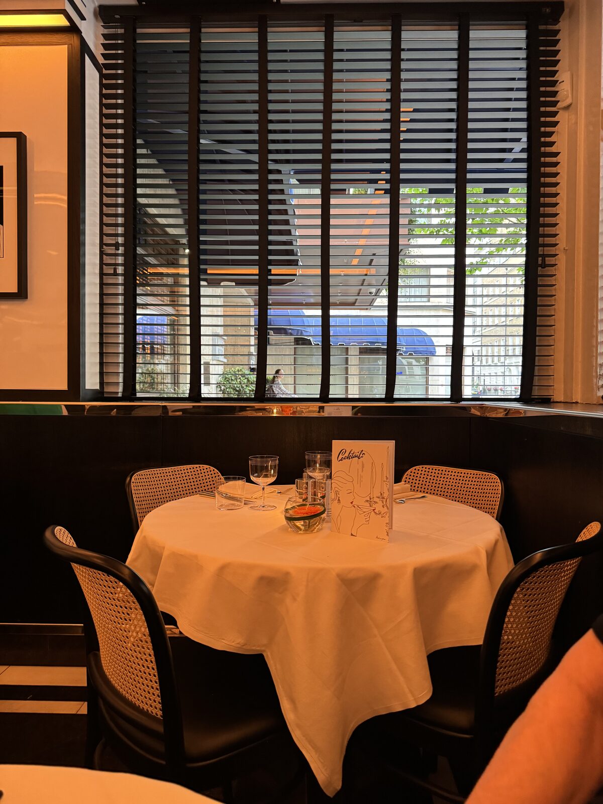 A corner table set under the blinds